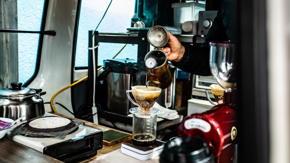 person pouring coffee in mug