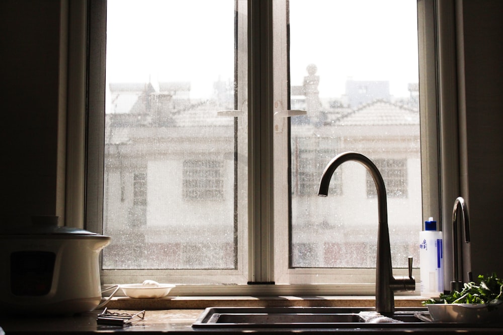 faucet and sink beside window inside kitchen