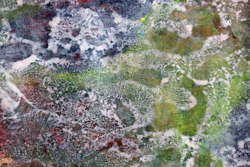 Abstract mixed-media artwork showing layered textures and mineral tones