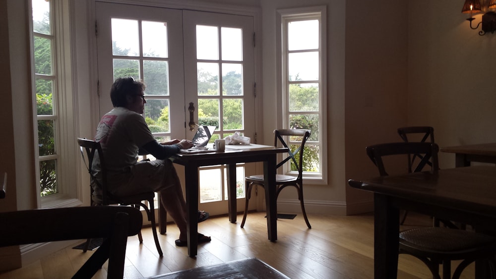 person sitting at the table near glass window