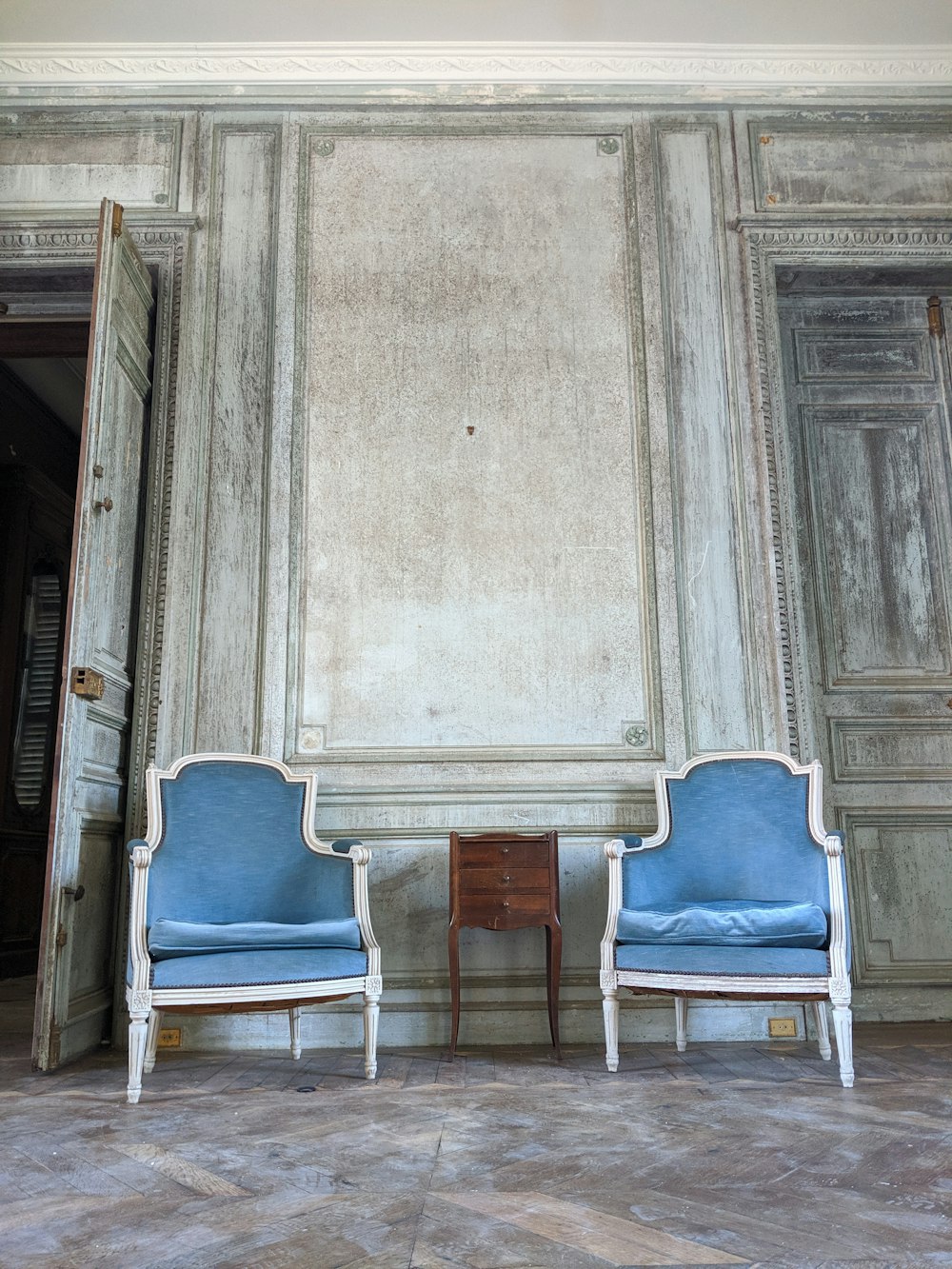 zwei blaue, mit Stoff gepolsterte Sessel