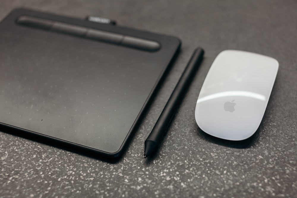 Apple Magic mouse beside pen