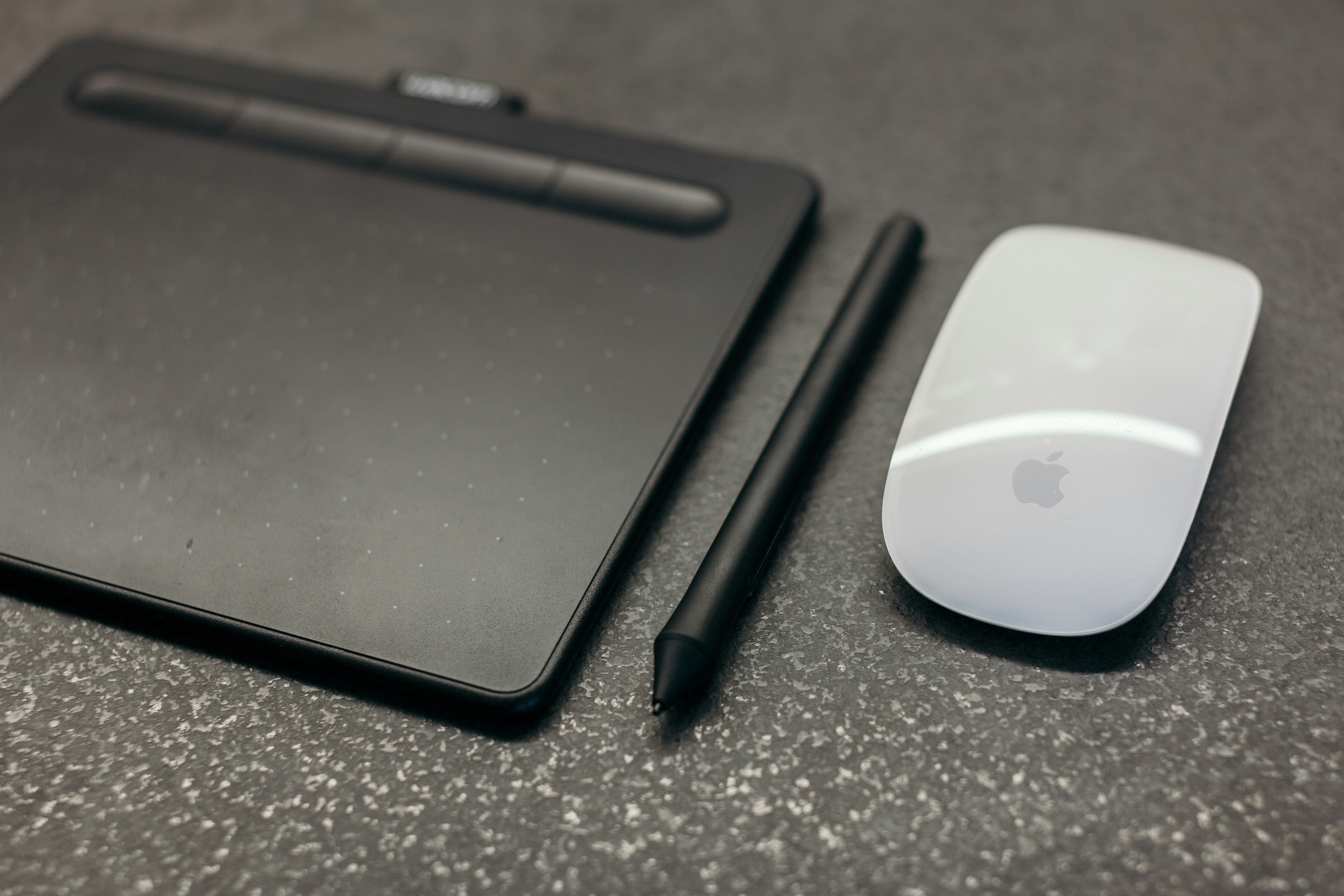 Apple Magic mouse beside pen