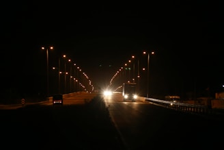 Nighttime shot of trucks moving along a highway illuminated by streetlights, symbolizing reliable execution.