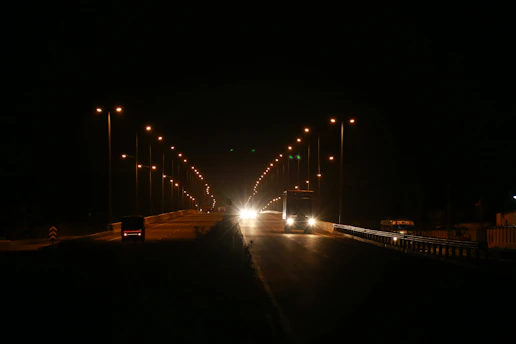 A nighttime highway scene illuminated by smart road sensors and autonomous vehicles in motion.