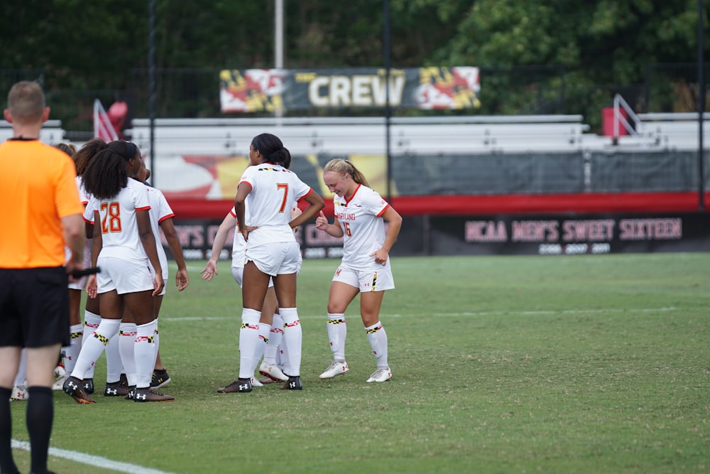 group of women playing soccer on field