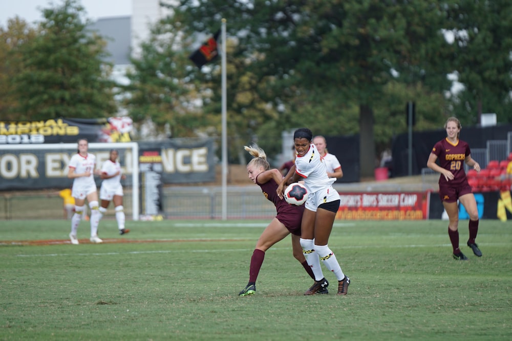 women playing soccer at daytime