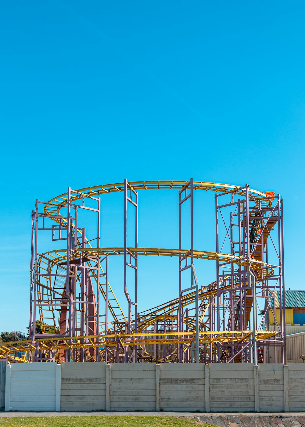 round gray and yellow metal building trusses under a calm blue sky