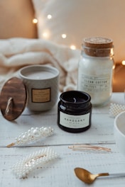 two small jar near white pearl hair clips