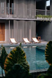 A stylish outdoor chaise lounge set up by a pool.