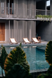 Elegant lounge chairs arranged by a hotel pool.