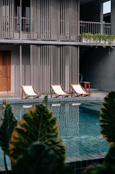 three white-and-brown wooden pool chairs