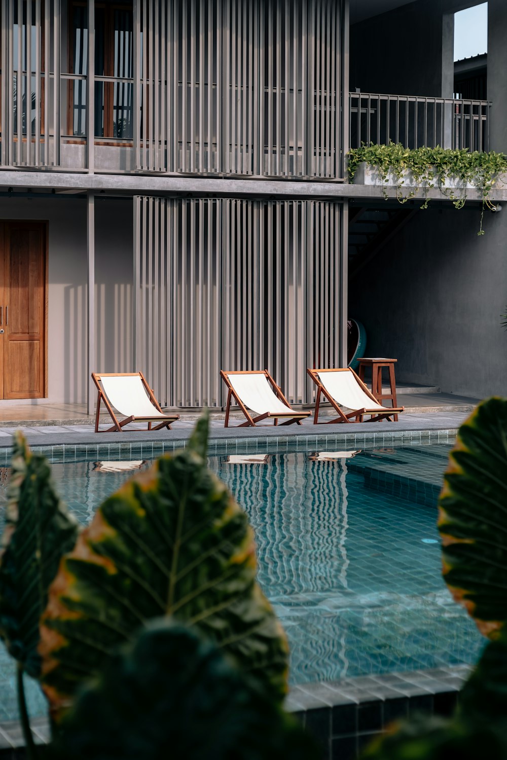 three white-and-brown wooden pool chairs