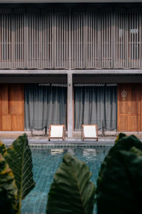 Swimming pool area with modern lounge chairs and a clean white background enhancing the space.