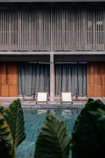 An elegant lounge chair placed beside a swimming pool.
