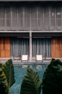 Cozy lounge chairs beside a swimming pool.