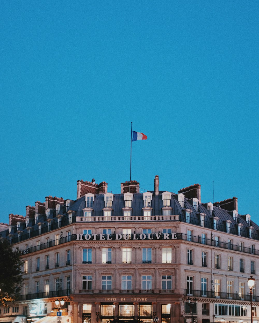 Edifício do Hotel Du Louvre sob o céu azul claro