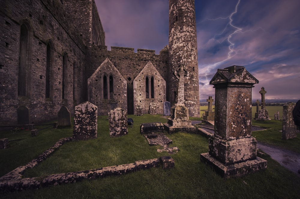 a graveyard with a tall tower in the background