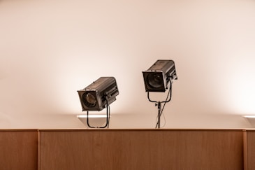 two black security cameras on white wall