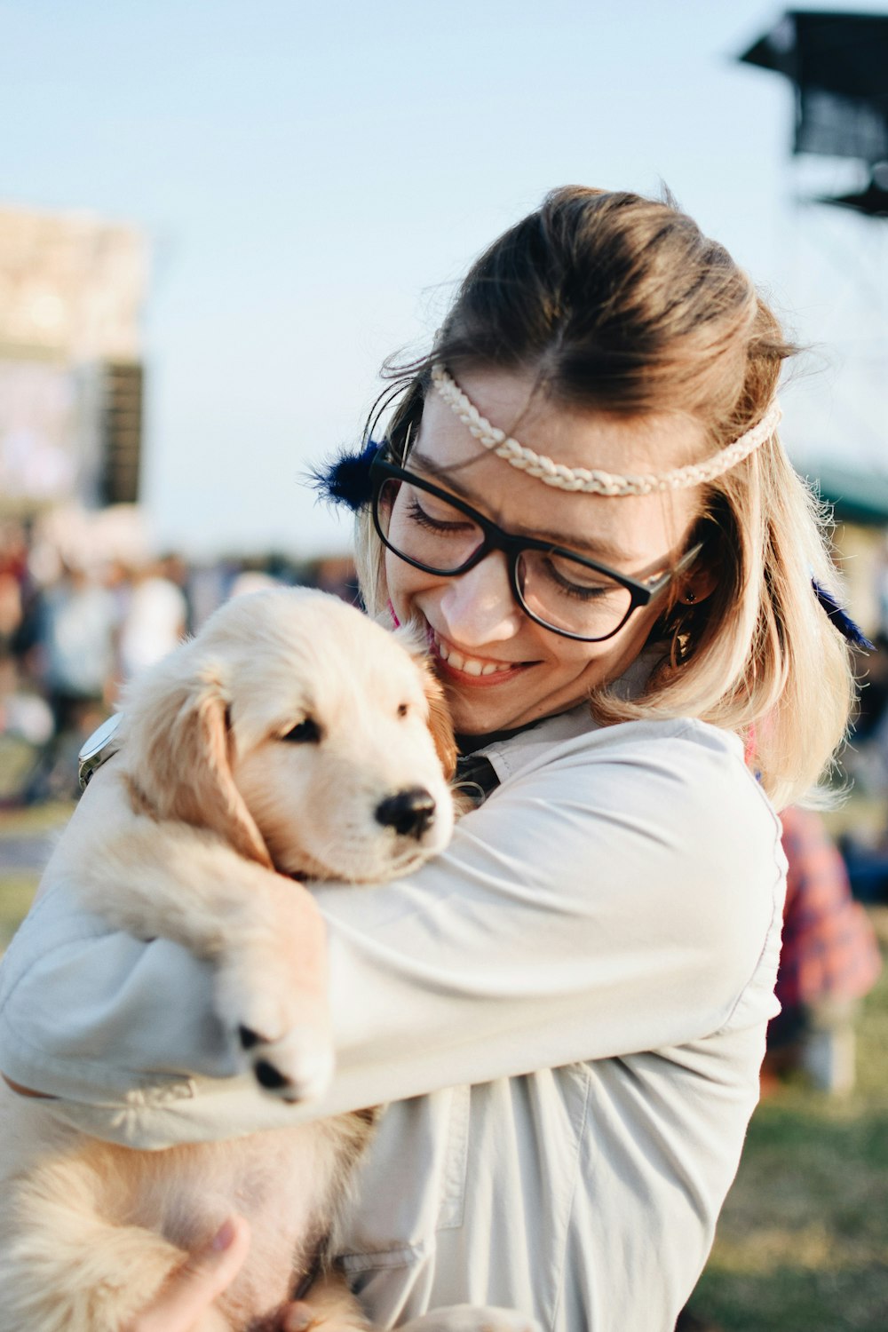 woman carrying golden retriever puppy