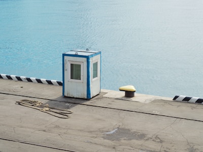 Guarded port entrance with surveillance cameras and patrol boats.