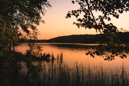 A calm lakeside scene at sunset, evoking a relaxed and unhurried atmosphere.