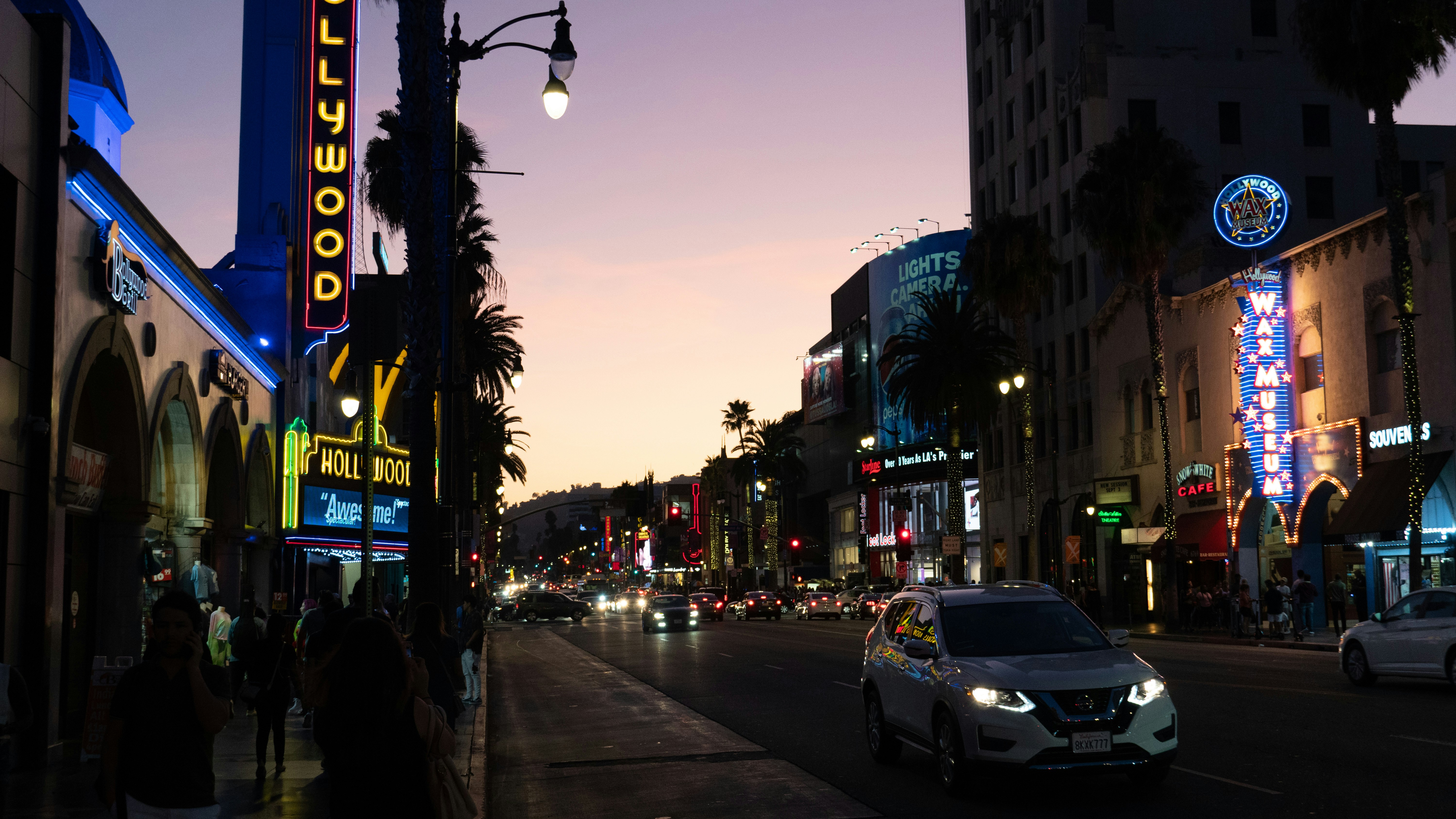 Aerial view of West Hollywood Sunset Boulevard at dusk, dark moody atmosphere, city lights beginning to glow
