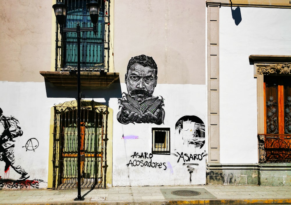 man's face graffiti wall at daytime