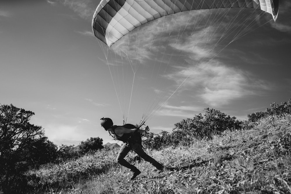 grayscale photography of person with parachute