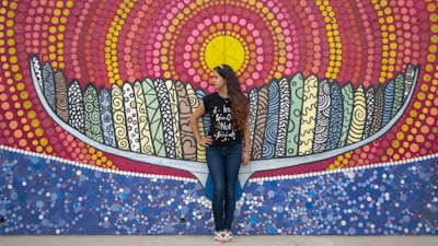 A vibrant photo of a model wearing a limited-edition graphic tee standing against a colorful urban mural.