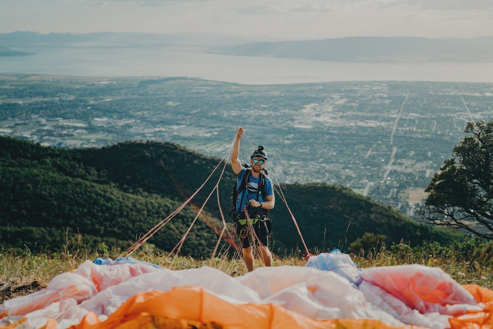 man holding parachute near mountain at daytime