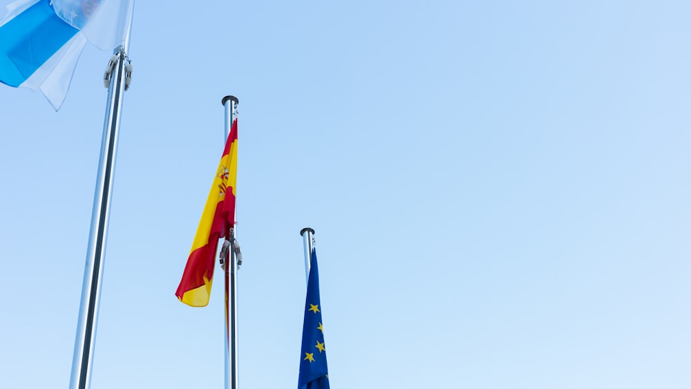 low-angle photography of three country flags