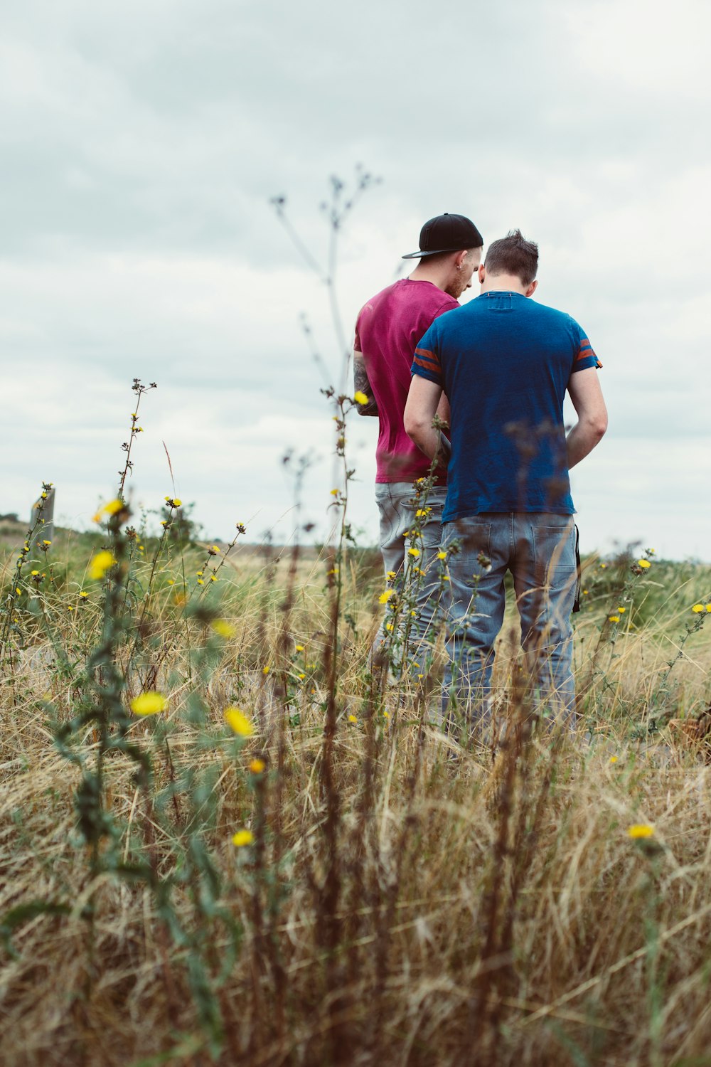 a couple of men standing next to each other in a field