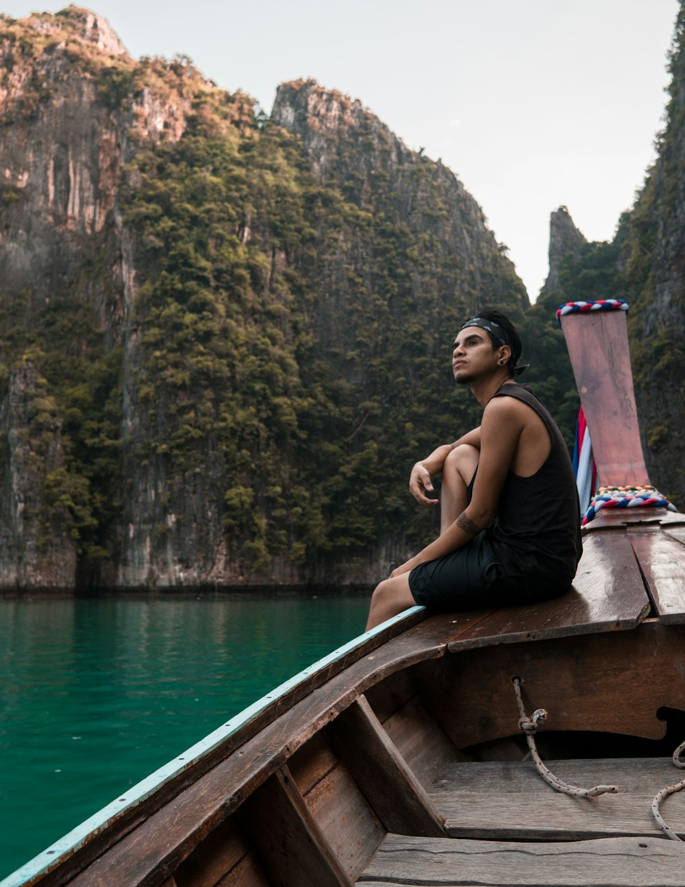 man sitting on boat during daytile