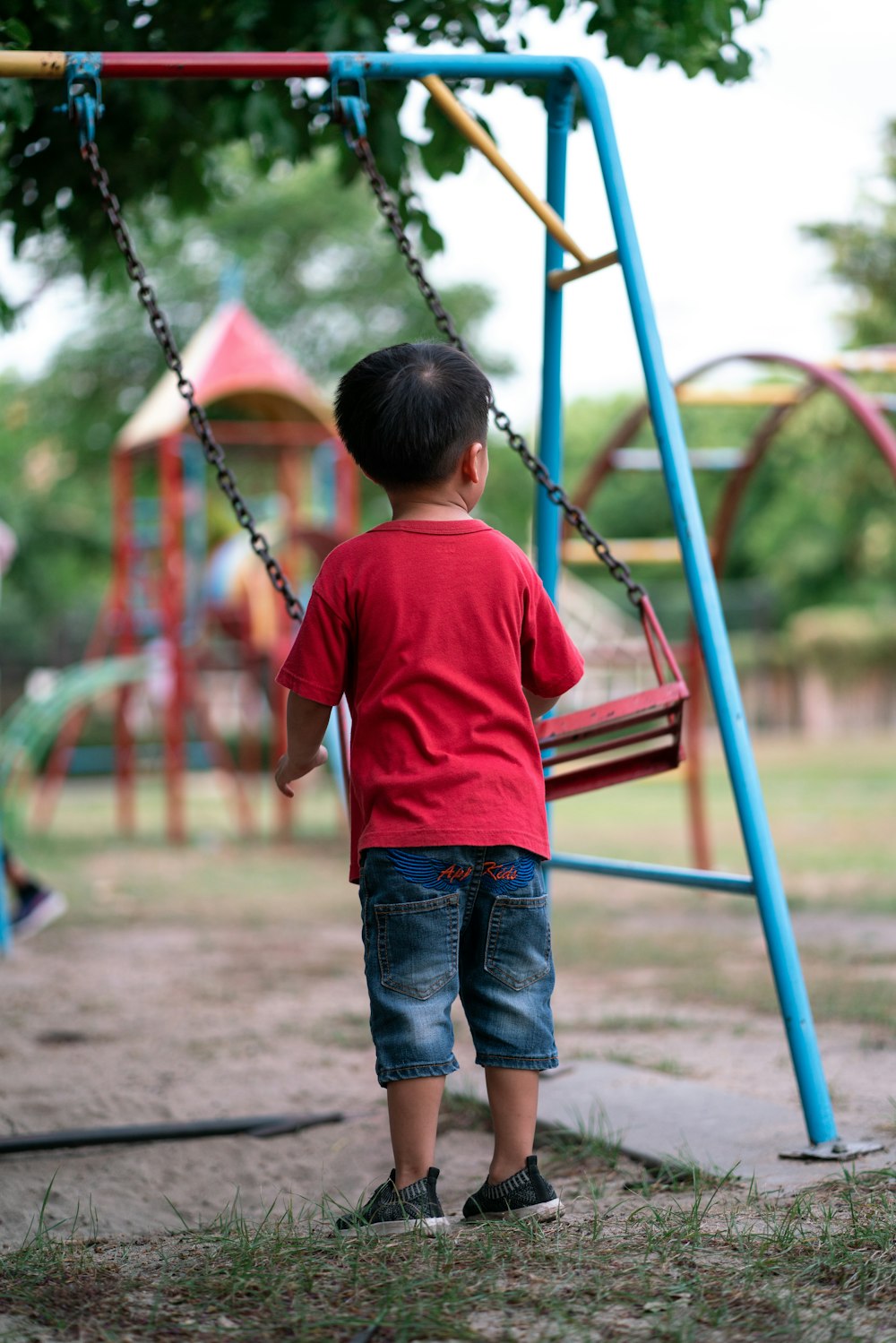 boy standing beside swing