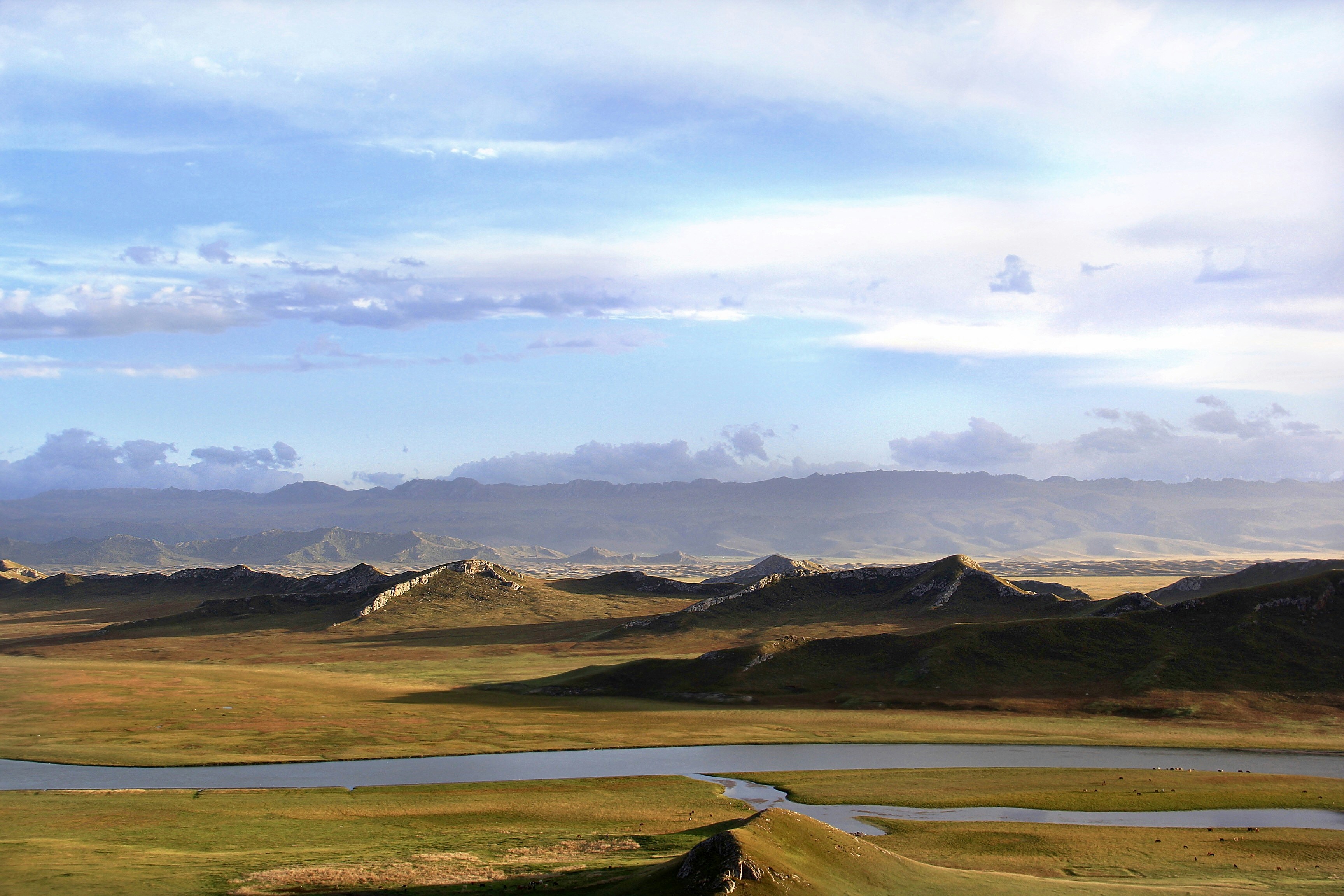 aerial photography of lake viewing mountain under blue and white skies during daytime