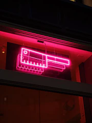 A shadowy butcher shop bathed in deep reds and blacks, with a flickering neon sign casting eerie light.