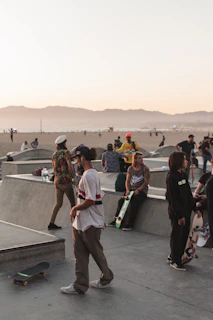 A group of friends hanging out by the beach with skateboards and surf gear
