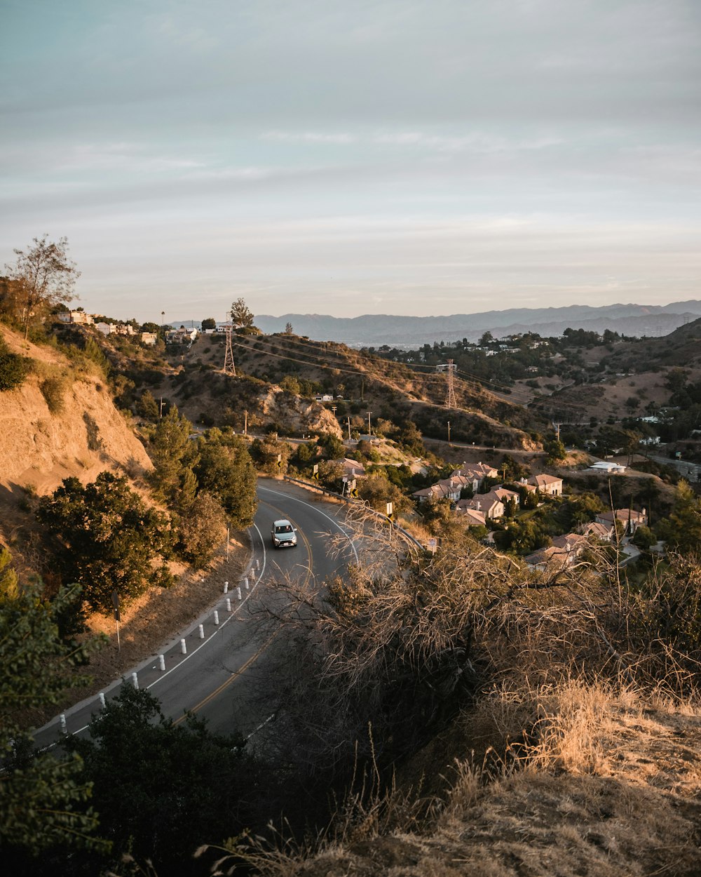 vehicle passing on road under cloudy sky