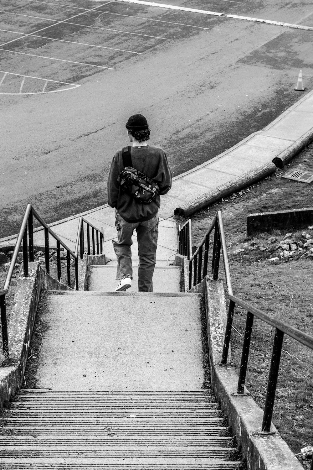 grayscale photography of man going down the stairs