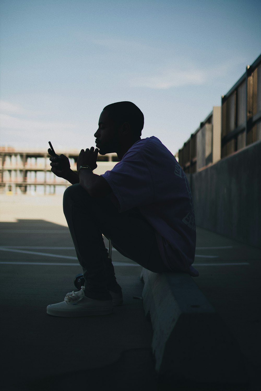 man sitting in the parking lot during daytime