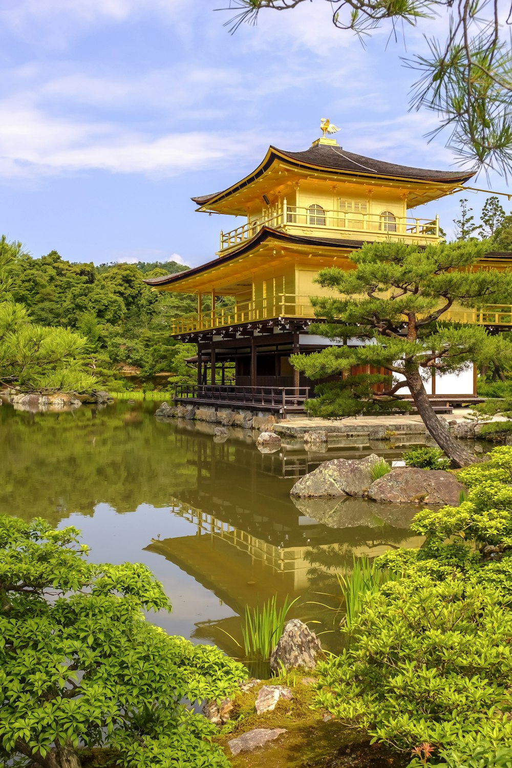 yellow and black temple near body of water under blue sky