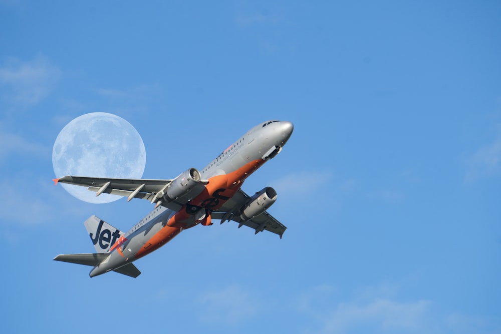 low-angle photography of gray and red Jet passenger plane