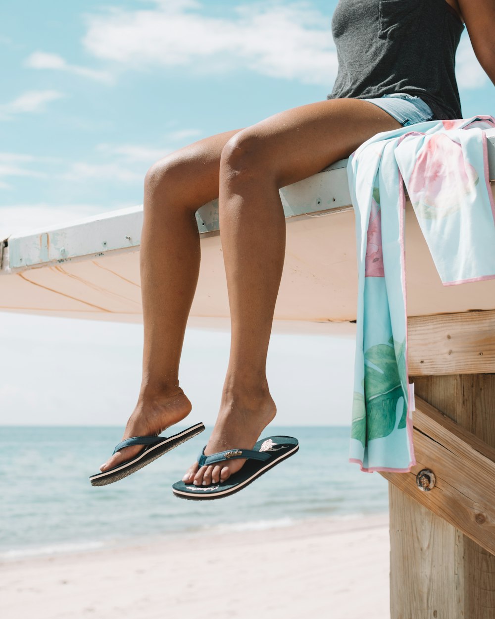 woman sitting on white wooden pier