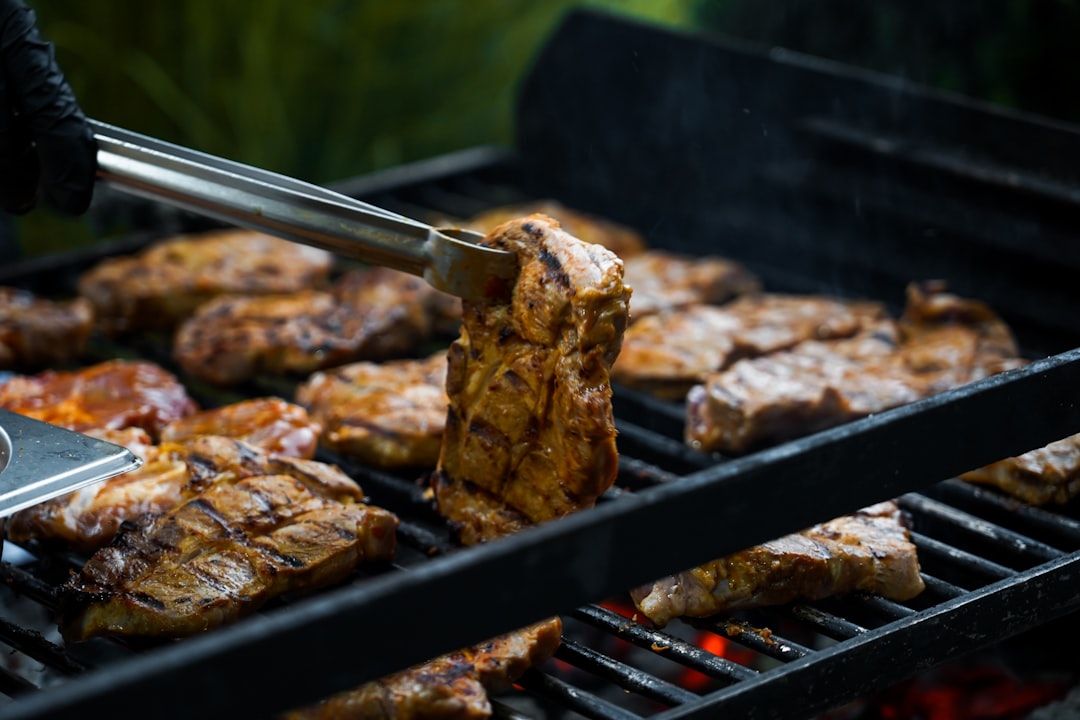 person holding thong holding grilled meat