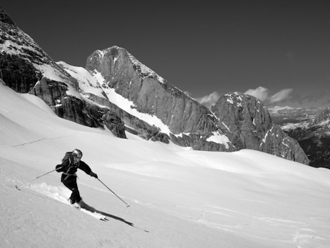 grayscale photo of person ice skiing during daytime
