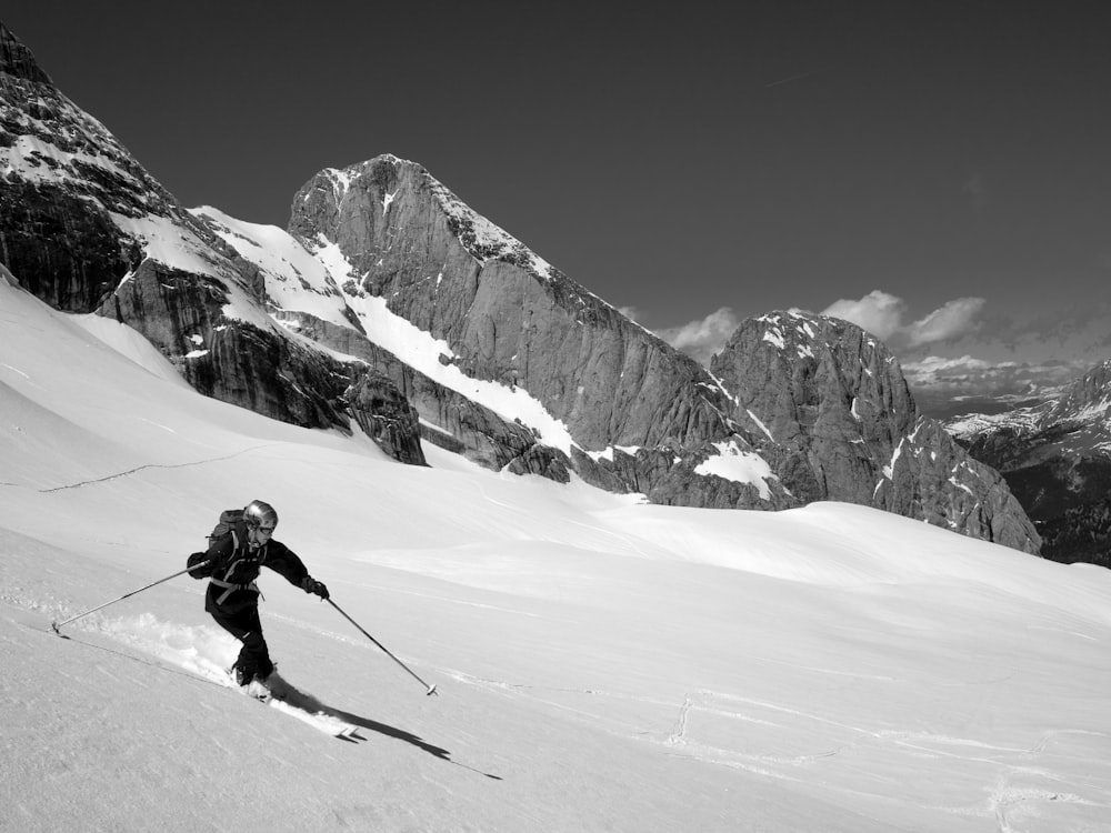 grayscale photo of person ice skiing during daytime