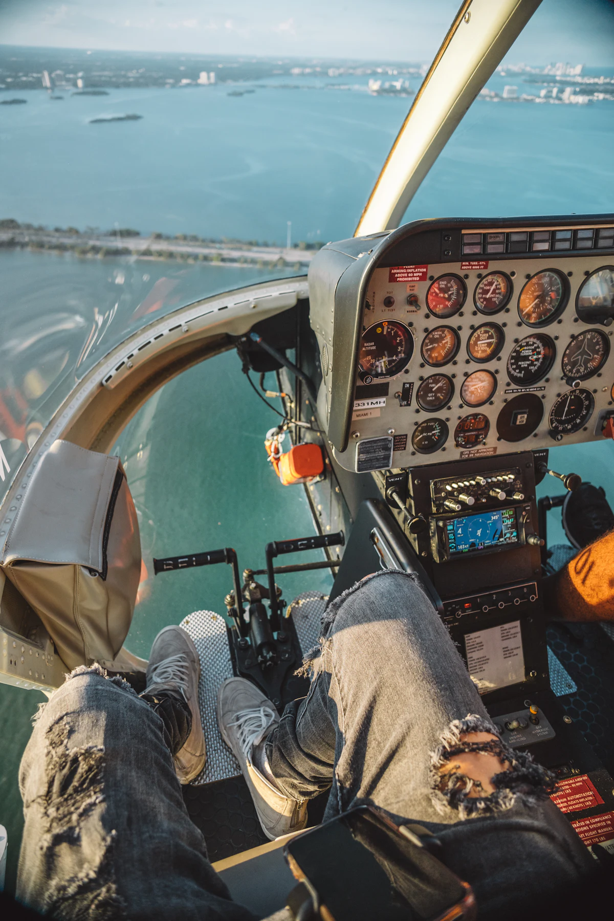 A passenger wearing a headset seated inside a helicopter on an early morning flight