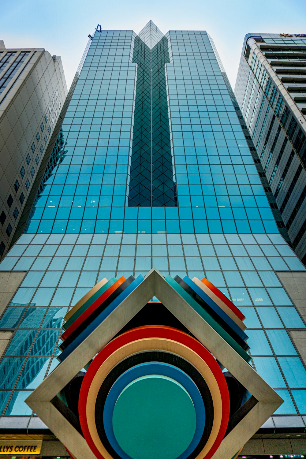 a very tall building with a very colorful sculpture in front of it