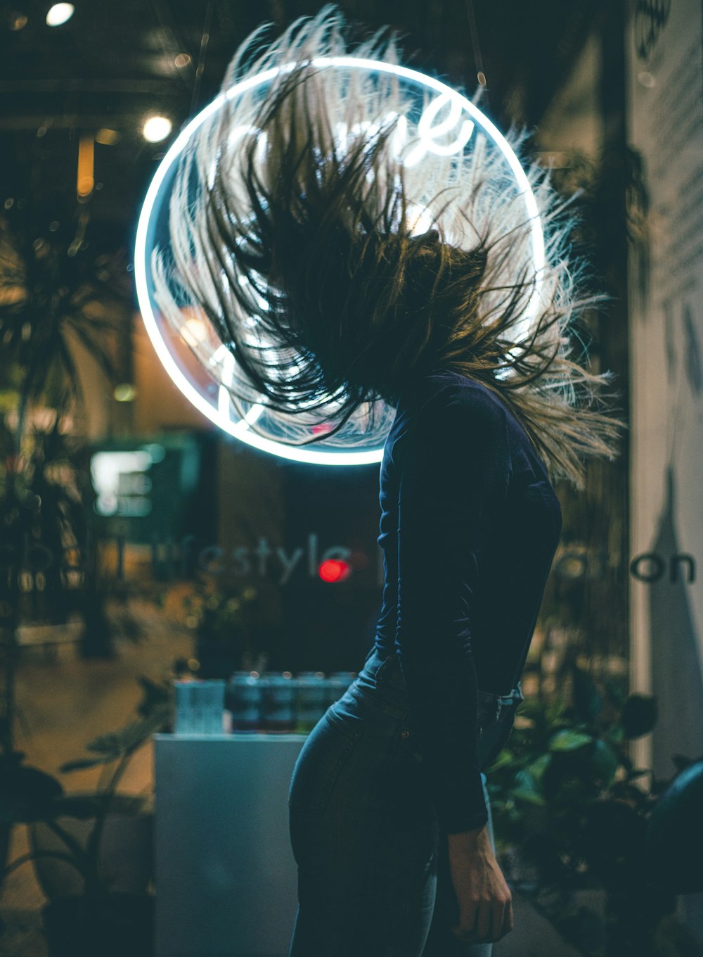 woman flipping hair near white LED signage
